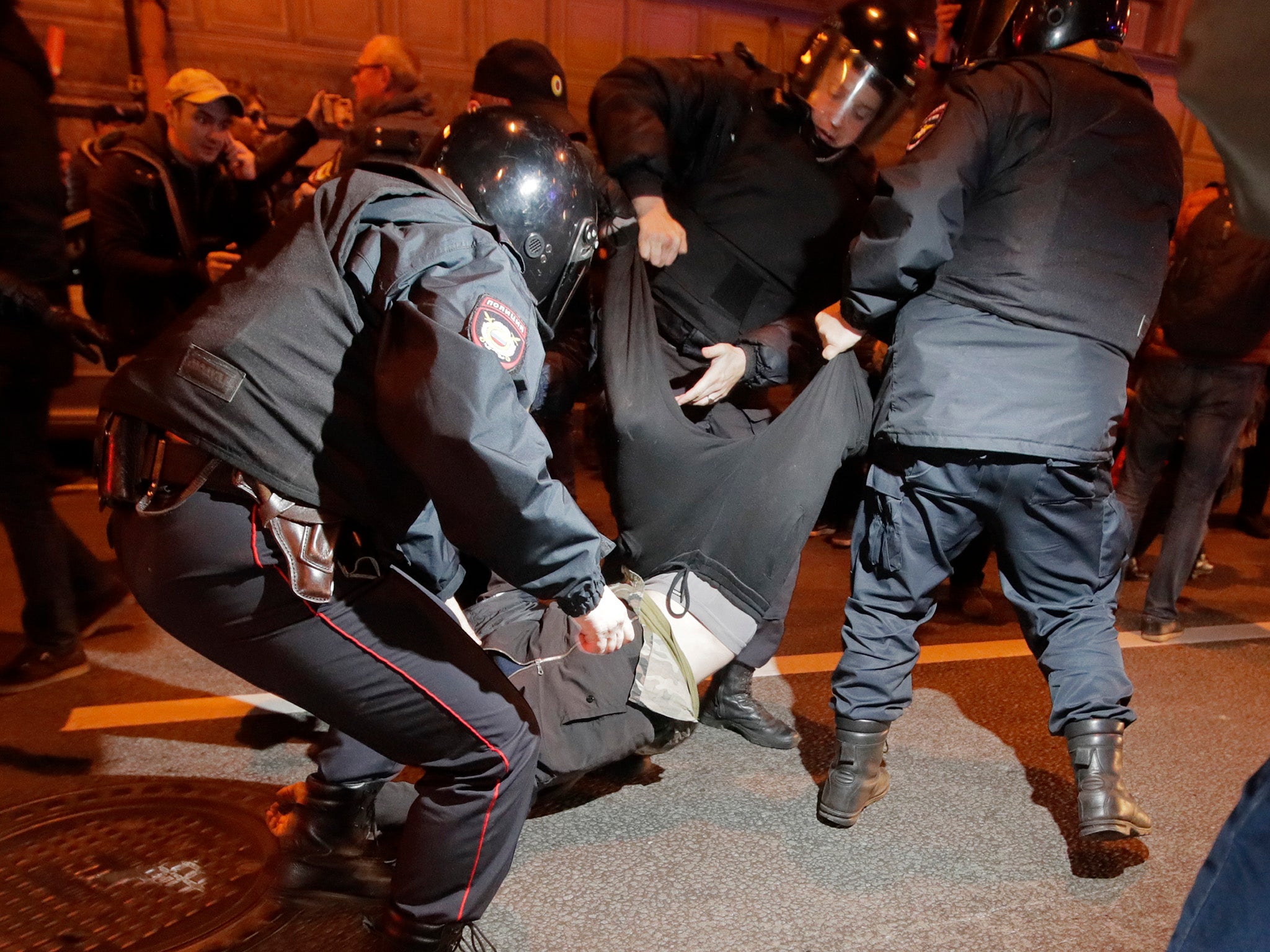 Riot police officers detain a protester during a rally in St.Petersburg