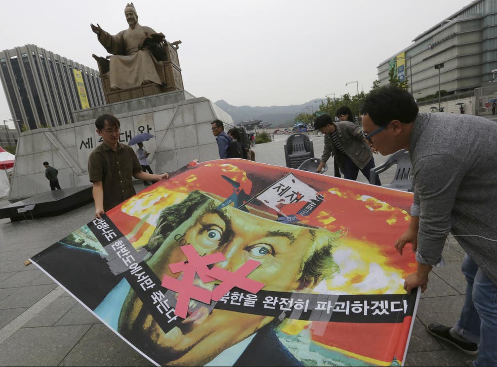 South Korean protesters carry a caricature of Donald Trump during a rally to denounce the US' policy against North Korea, near the American Embassy in Seoul on 26 September