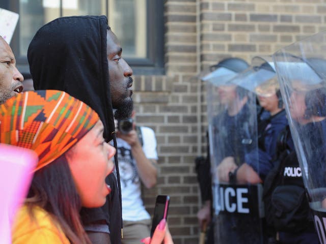 Missouri State Representative Bruce Franks stands before police in riot gear as protestors demonstrate following a not guilty verdict of a police officer on 15 September 2017 in St. Louis, Missouri.