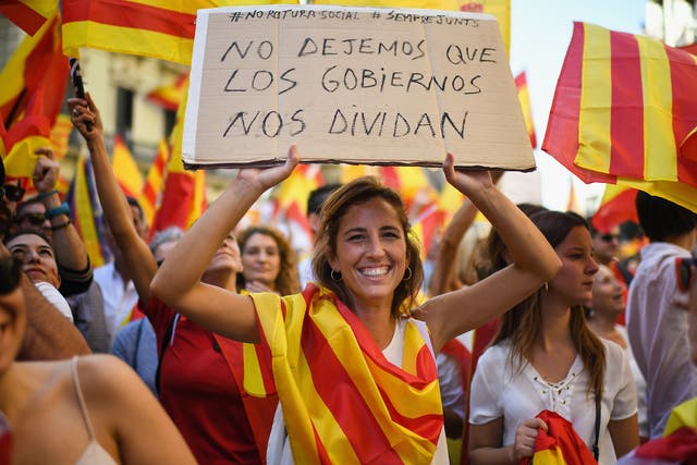 Pro-unity supporters march through Barcelona carrying a sign that reads: 'Let's not let governments divide us'