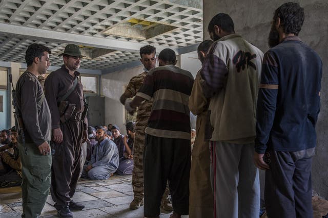 Men suspected of being Isisfighters are searched at a security screening centre near Kirkuk, Iraq