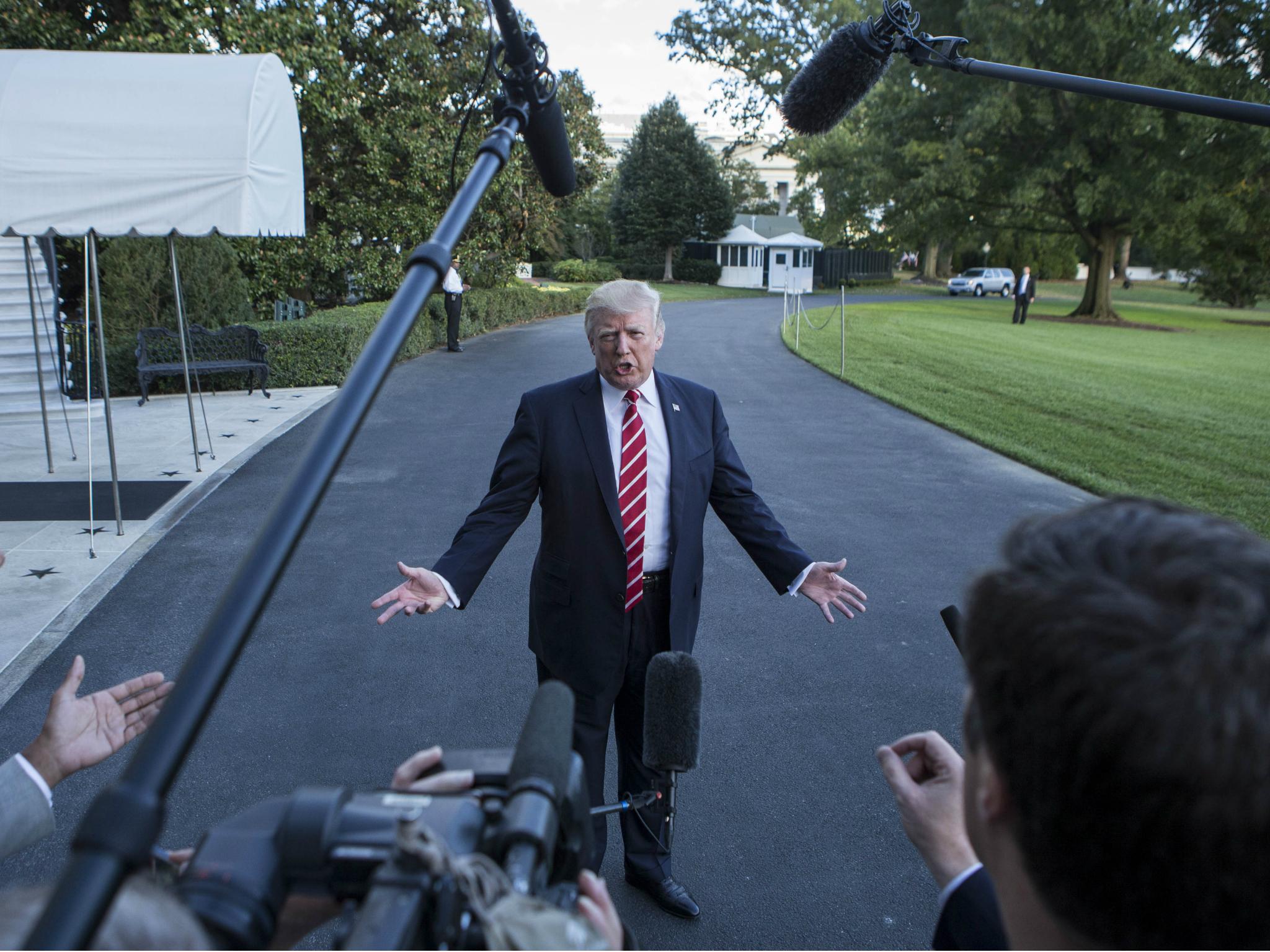 Donald Trump speaks to reporters outside the White House