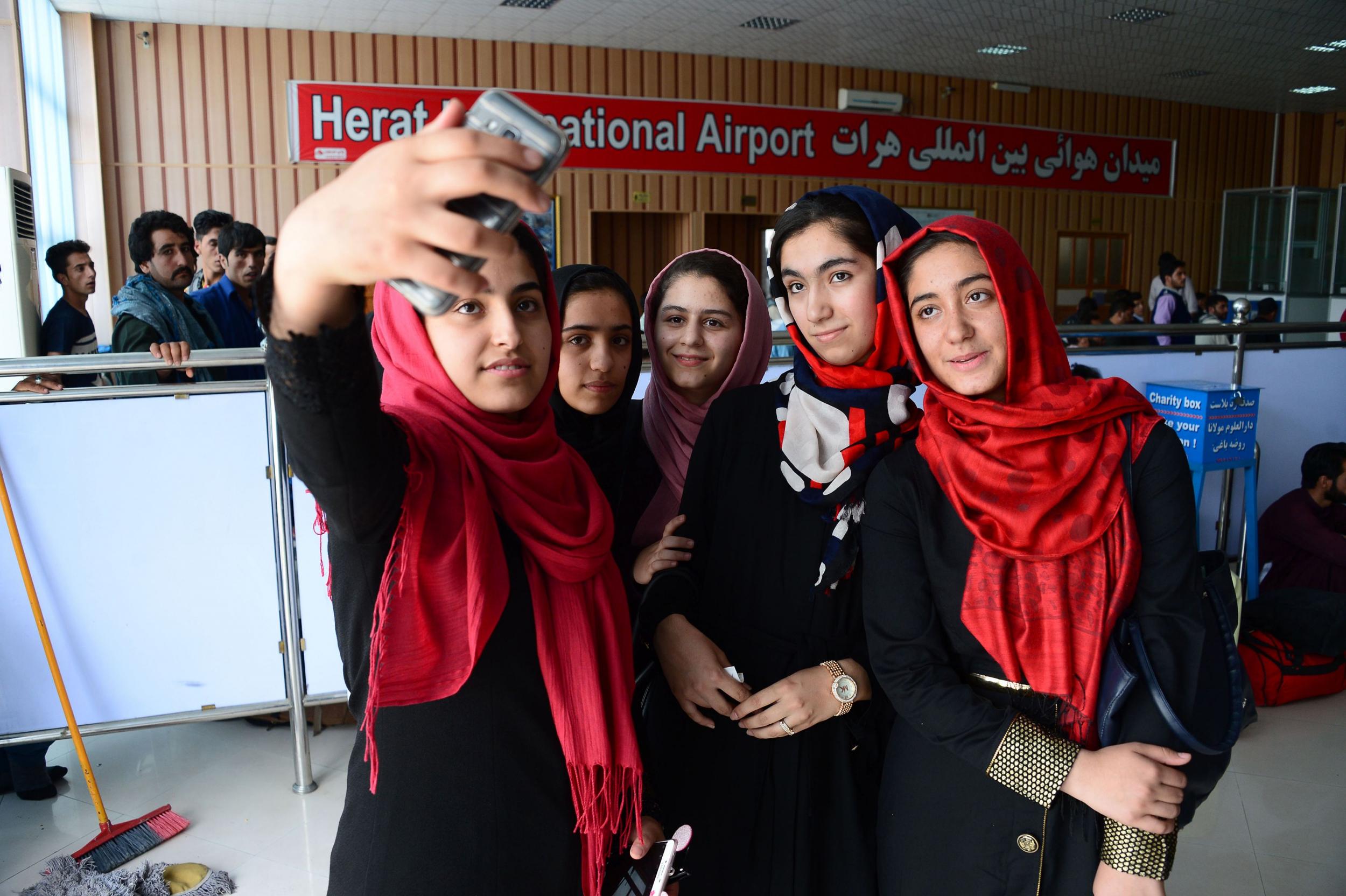 Afghan teenagers from the Afghanistan Robotic House initiative take pictures at Herat International Airport  before travelling to the US for a competition