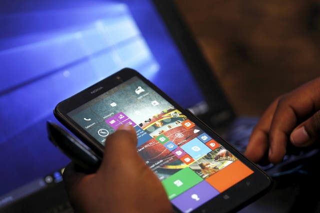 A Microsoft delegate checks applications on a smartphone during the launch of the Windows 10 operating system in Kenya's capital Nairobi, July 29, 2015