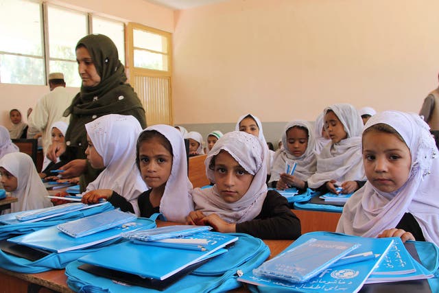 Girls attend school in Afghanistan. There pens and bags were provided by Unicef