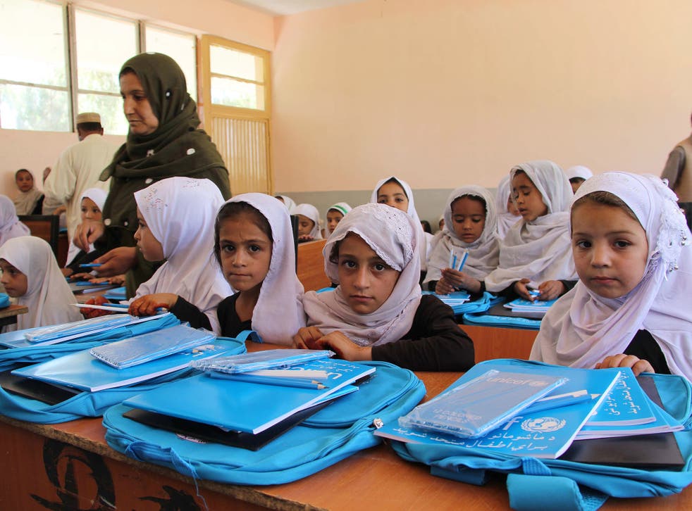 Girls attend school in Afghanistan. There pens and bags were provided by Unicef