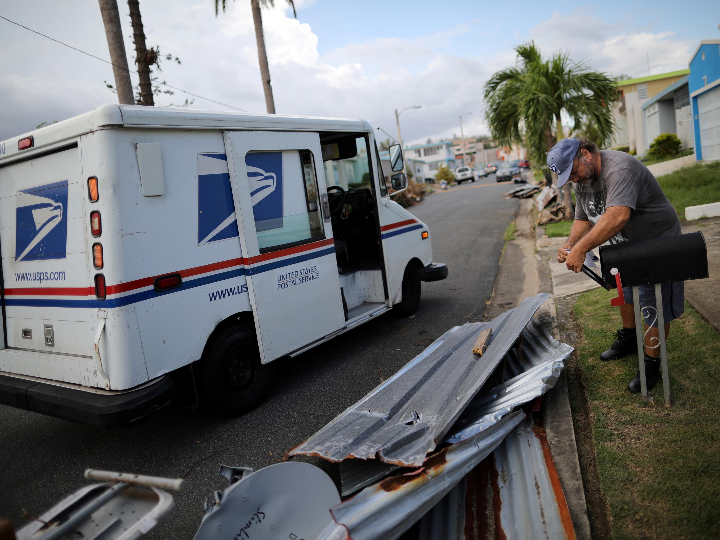 Alfredo Martinez, a postman for the US Postal Service delivers the mail at an area damaged by Hurricane Maria in San Juan, Puerto Rico