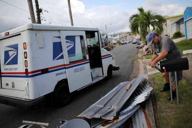 Alfredo Martinez, a postman for the US Postal Service delivers the mail at an area damaged by Hurricane Maria in San Juan, Puerto Rico