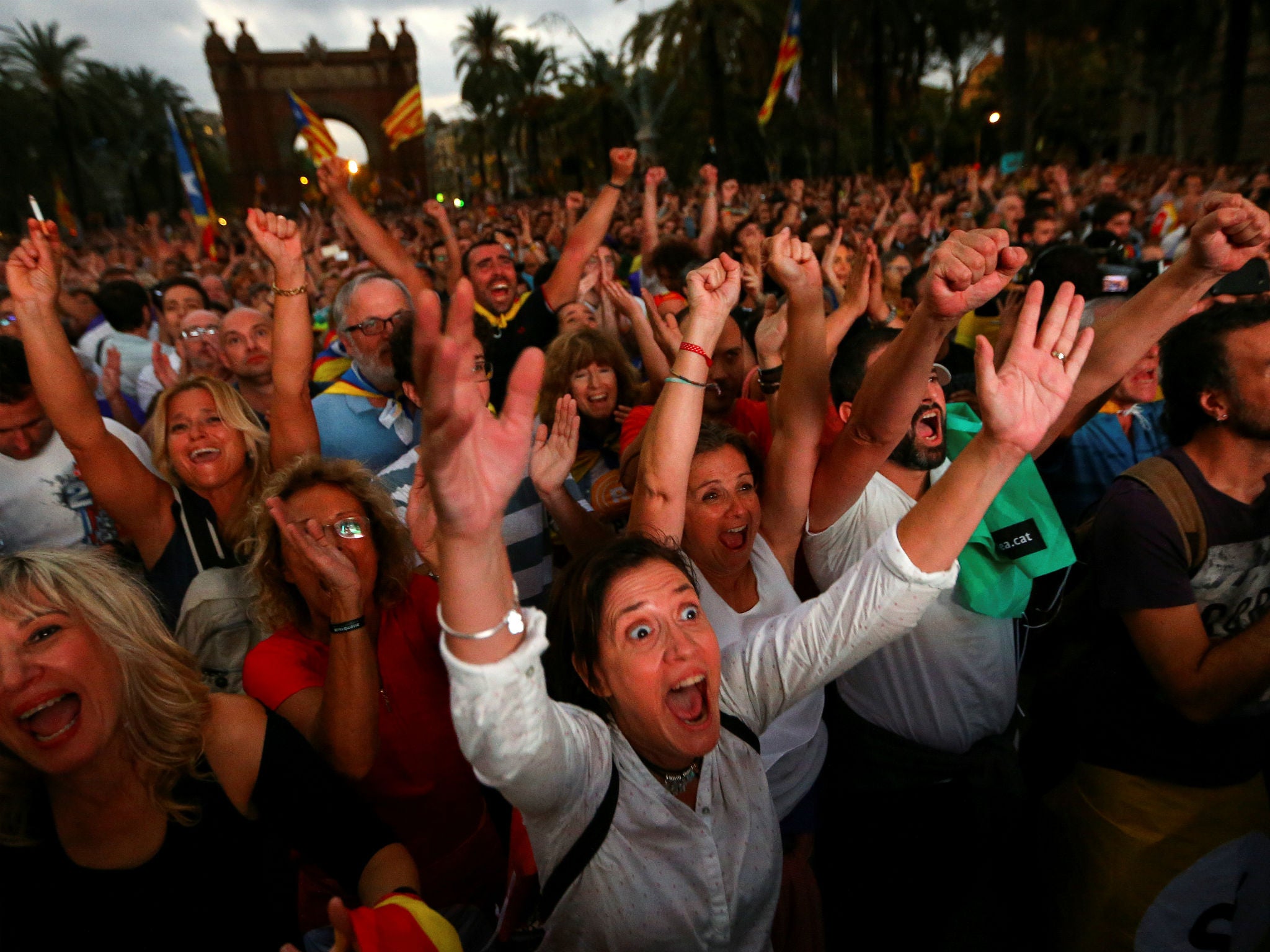 Crowds watch a session of the Catalonian regional parliament on a giant screen at a pro-independence rally in Barcelona