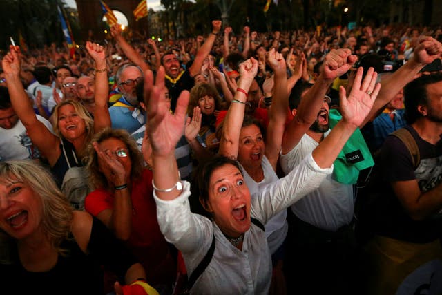 Crowds watch a session of the Catalonian regional parliament on a giant screen at a pro-independence rally in Barcelona