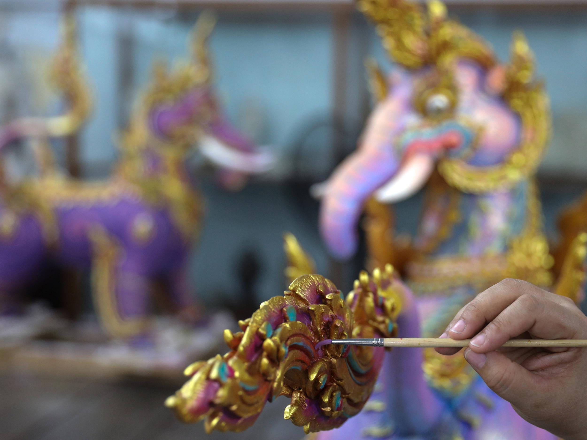 An artist works on a deity sculpture which will decorate the funeral pyre of the late King Bhumibol Adulyadej, near the Grand Palace in Bangkok