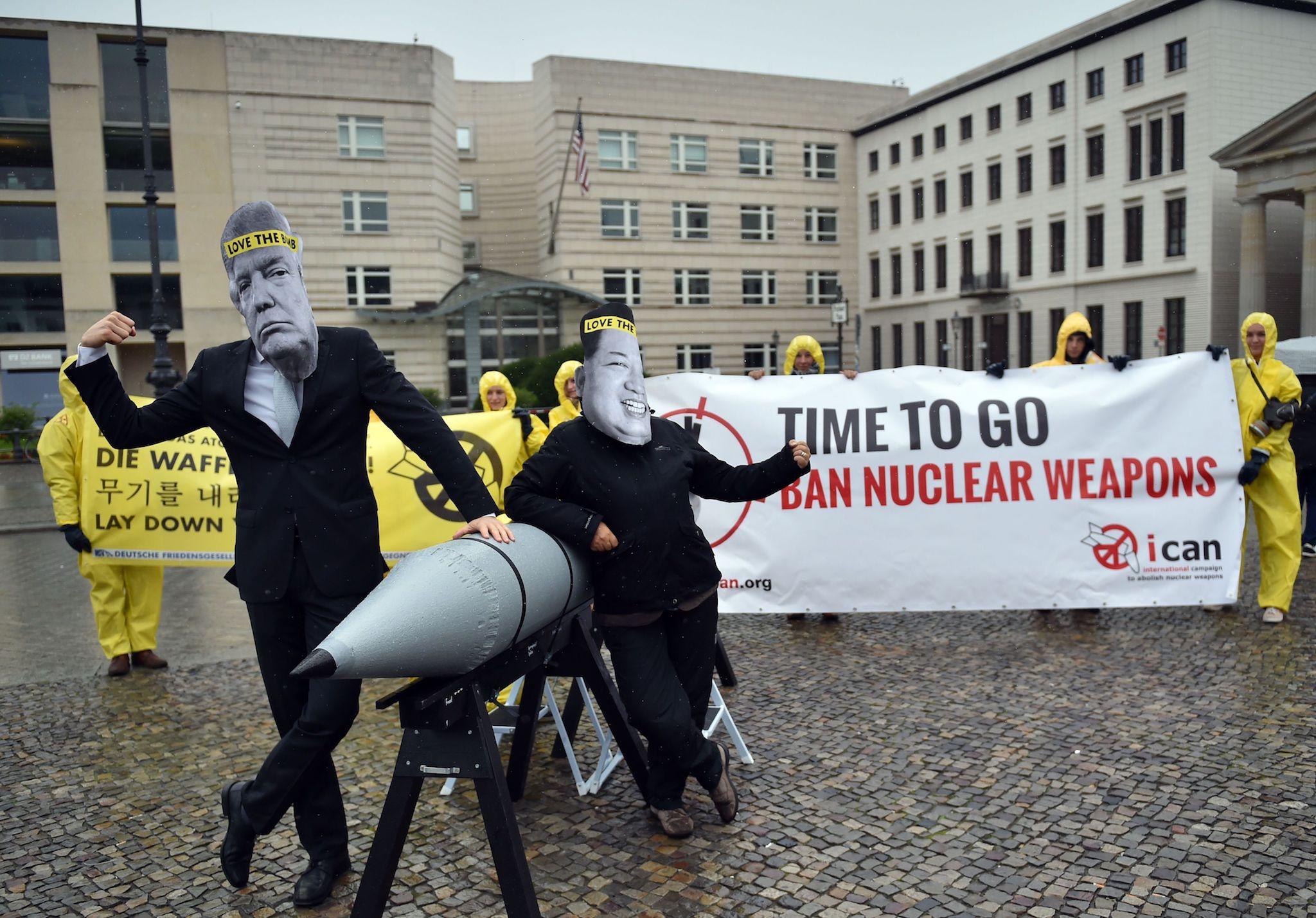 Picture taken on September 13, 2017 shows activists of the International campaign to abolish Nuclear Weapons (ICAN) wearing masks of US President Donald Trump and North Korea's leader Kim Jong-un as they demonstrate in front of the US embassy in Berlin
