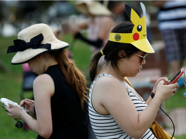 Women play Pokemon Go at an event in Yokohama, Japan August 9, 2017.