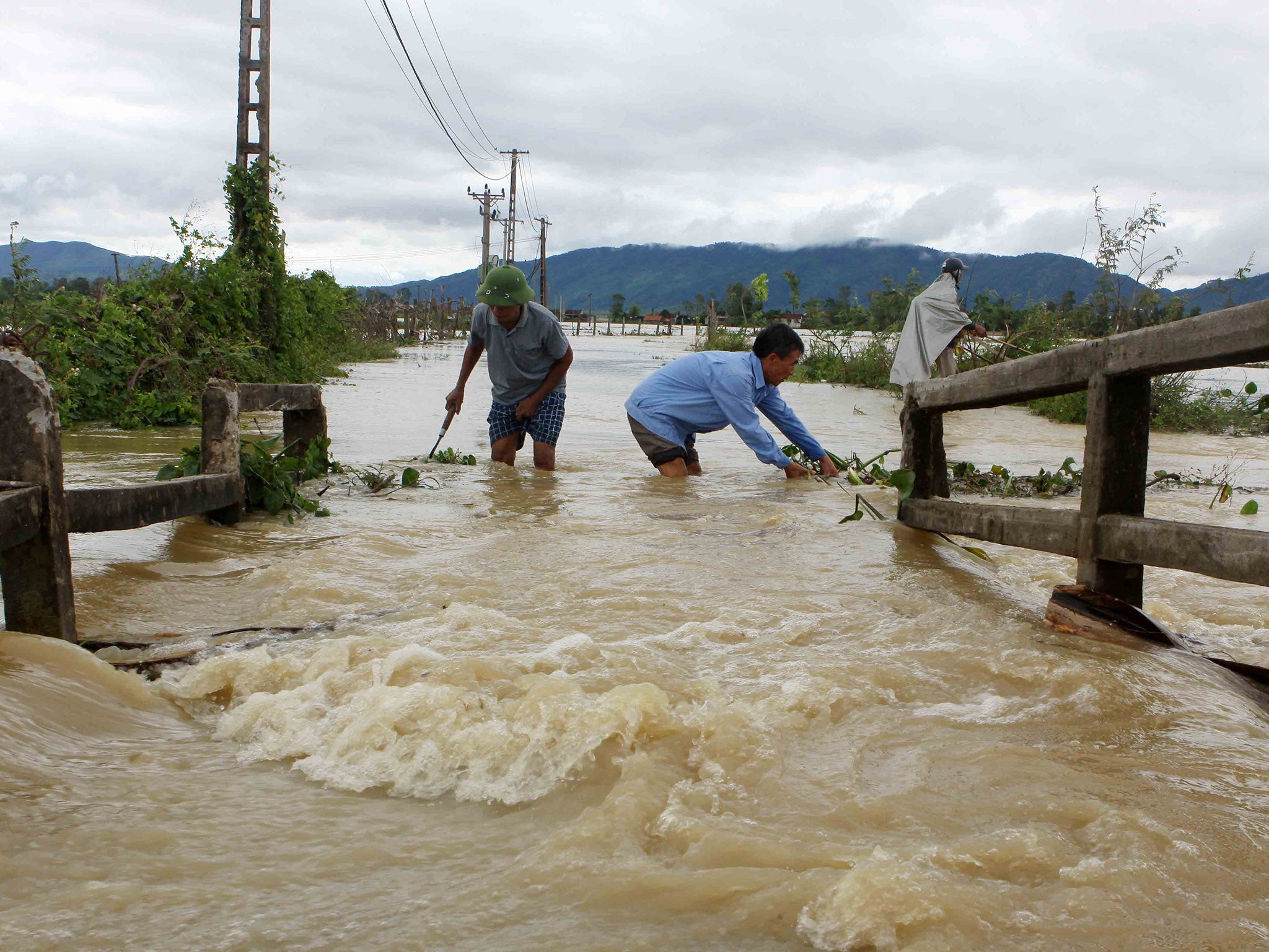 Men wading through the flooded areas of in the central province of Nghe An
