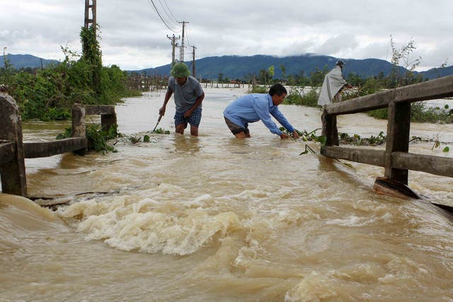 Men wading through the flooded areas of in the central province of Nghe An