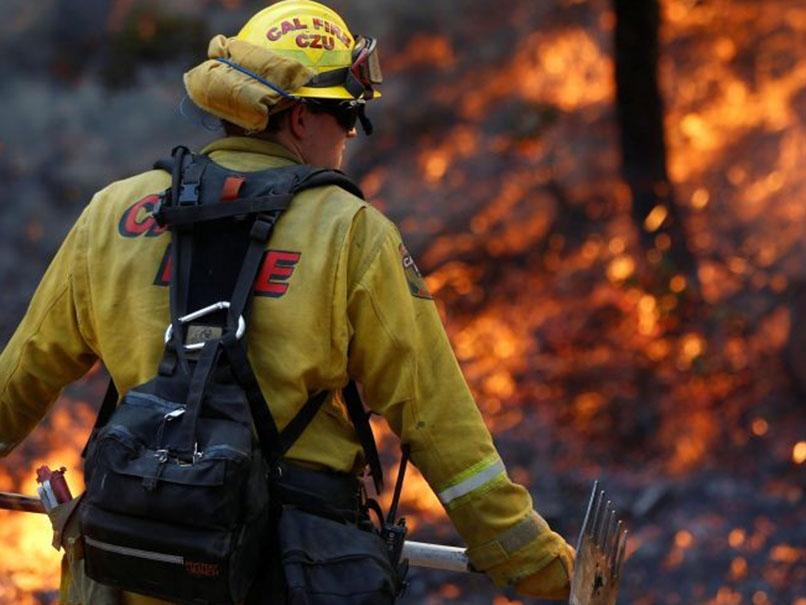 Firefighters work to defend homes from an approaching wildfire in Sonoma, California
