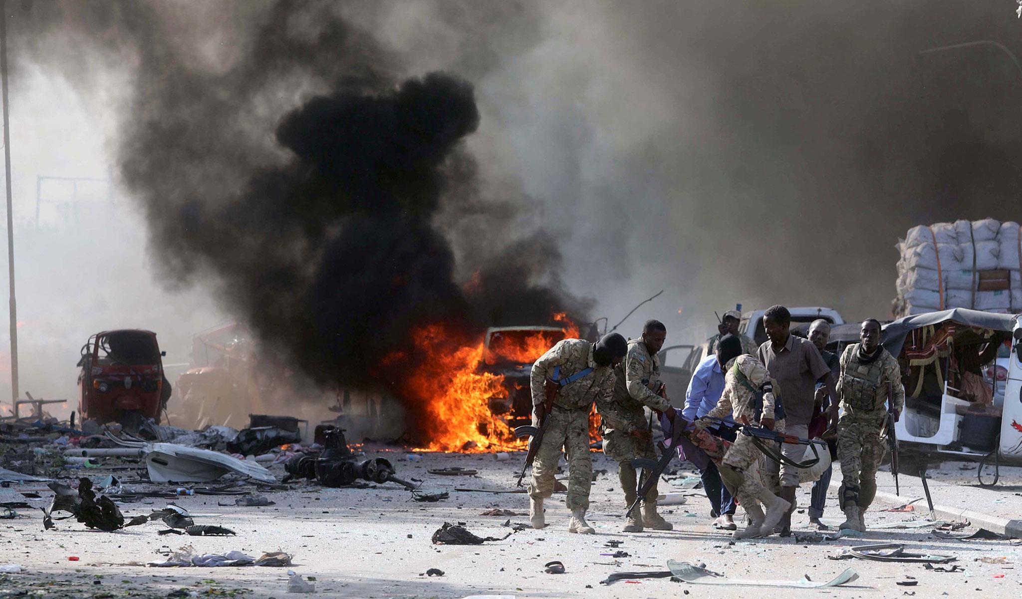Somali Armed Forces evacuate their injured colleague, from the scene of an explosion in KM4 street in the Hodan district of Mogadishu, Somalia