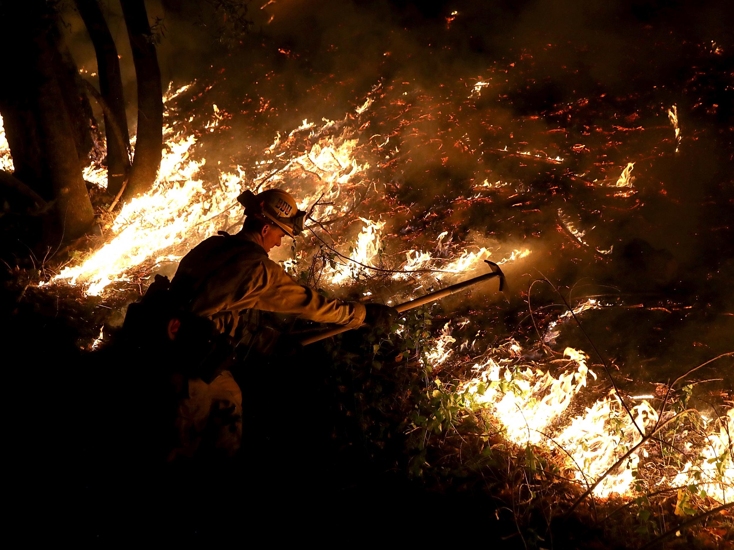 A firefighter works to contain fire in California
