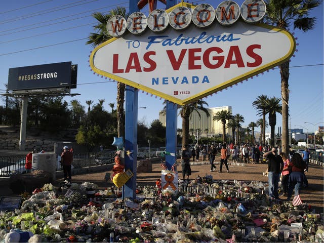 Flowers, candles and other items surround the famous Las Vegas sign at a makeshift memorial for victims of the mass shooting.
