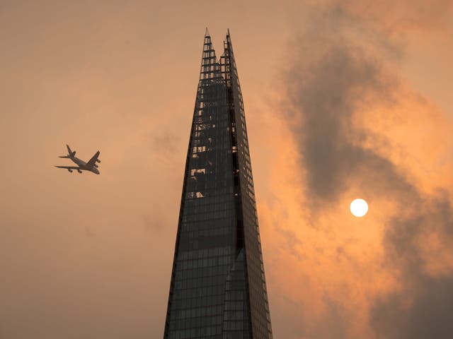 A plane flies past the Shard in central London