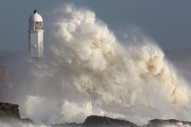 Huge waves strike the harbour wall and lighthouse at Porthcawl, South Wales, on October 16, 2017 as Storm Ophelia hits the UK and Ireland.