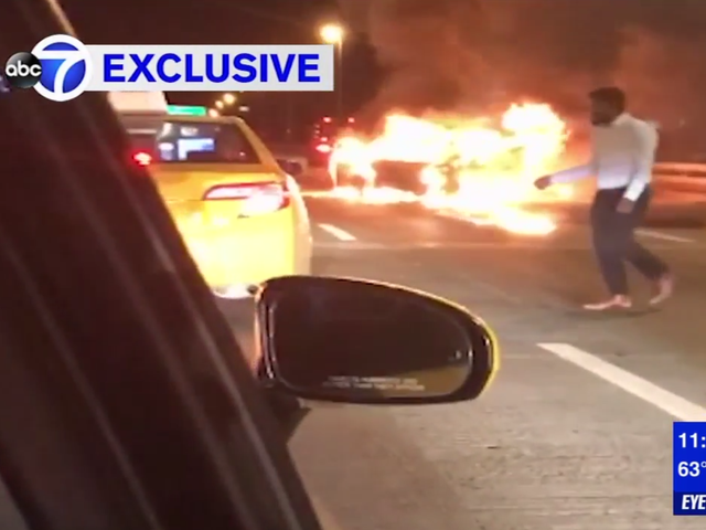 Footage shows a man hailing a cab next to a burning car on a New York expressway