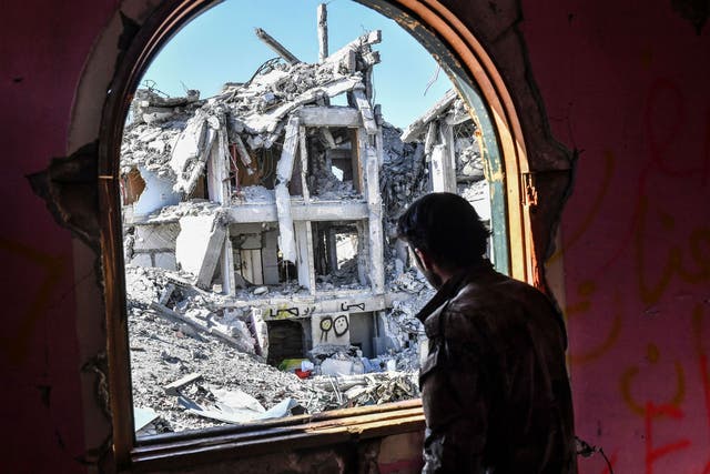 A member of the SDF looks at the destruction, during the battle for the city 