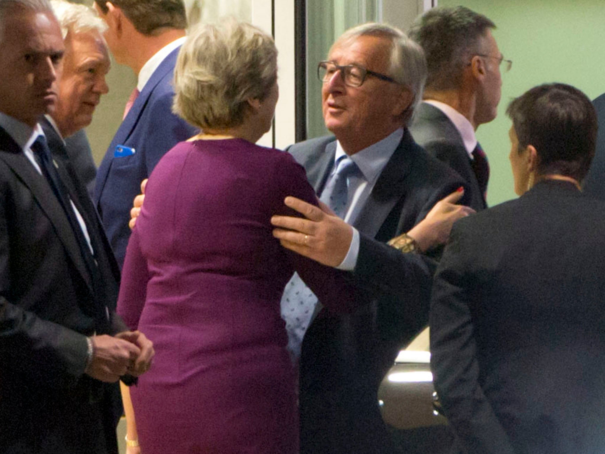 Jean-Claude Juncker embraces Theresa May as David Davis looks on