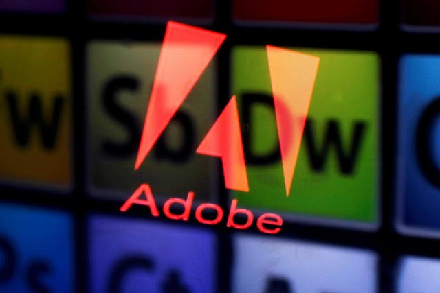 An Adobe logo and Adobe products are seen reflected on a monitor display and an iPad screen, in this picture illustration July 8, 2013