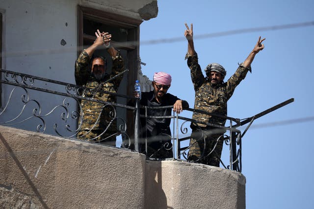 Fighters of Syrian Democratic Forces gesture the 'V' sign at the frontline in Raqqa