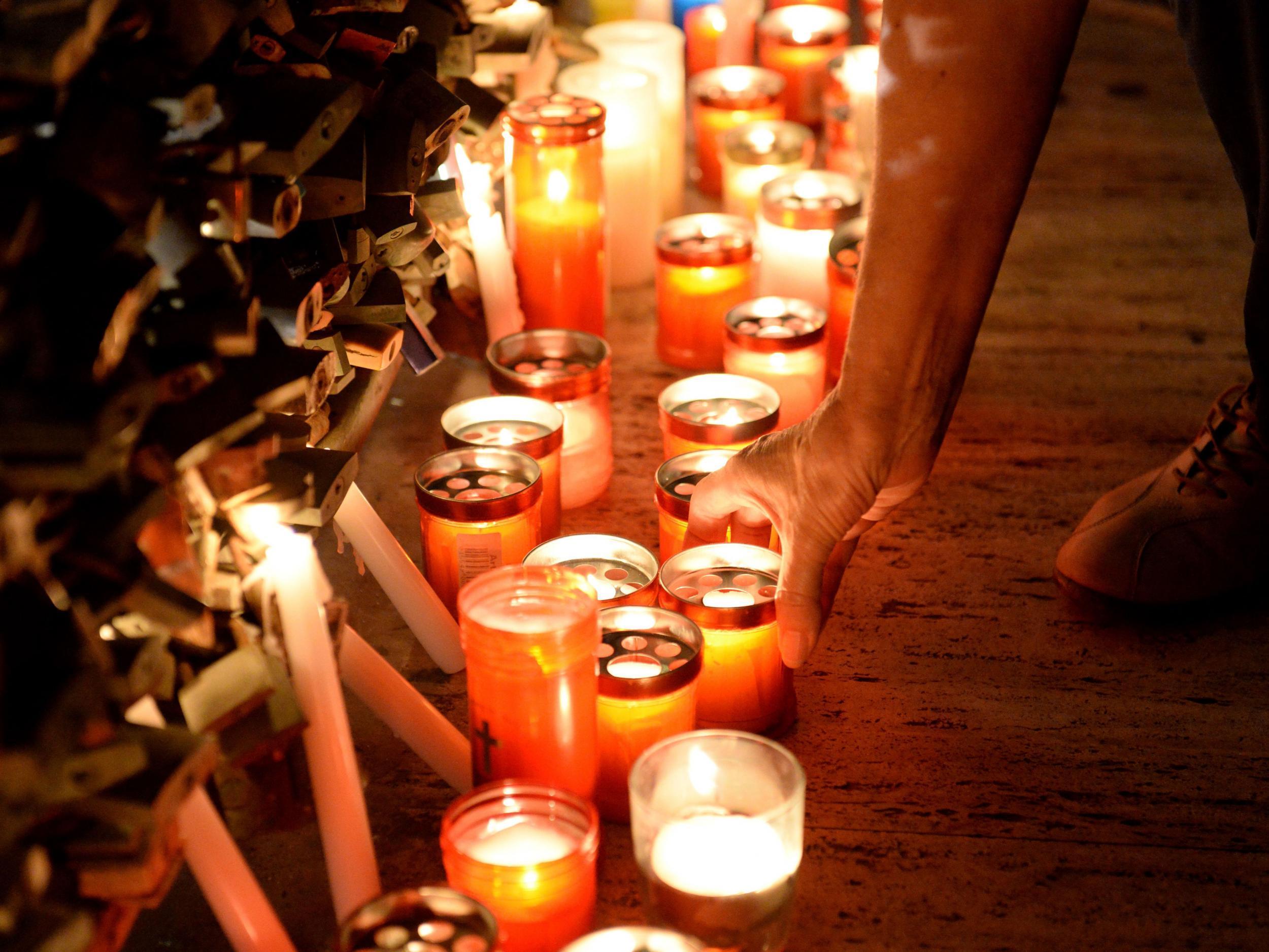 A person lights a candle during a candlelight vigil in Sliema held in tribute to late journalist Daphne Caruana Galizia