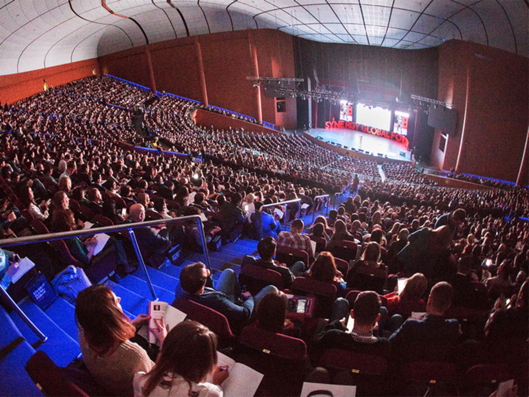 Lasted forum. Зал со сценой. Огромный зал людей. Концертный зал с людьми. Полный зал.