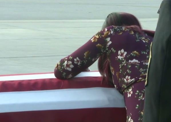 Myesha Johnson weeps over widow's casket at Miami International Airport
