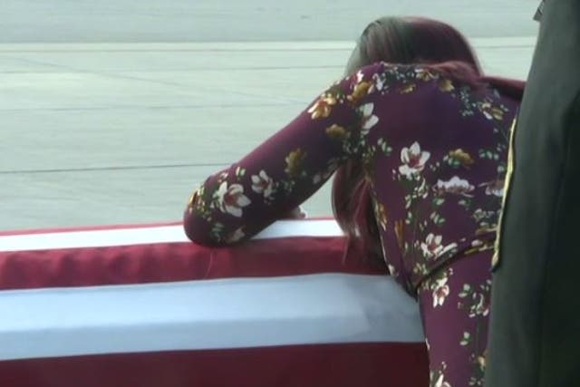 Myesha Johnson weeps over widow's casket at Miami International Airport