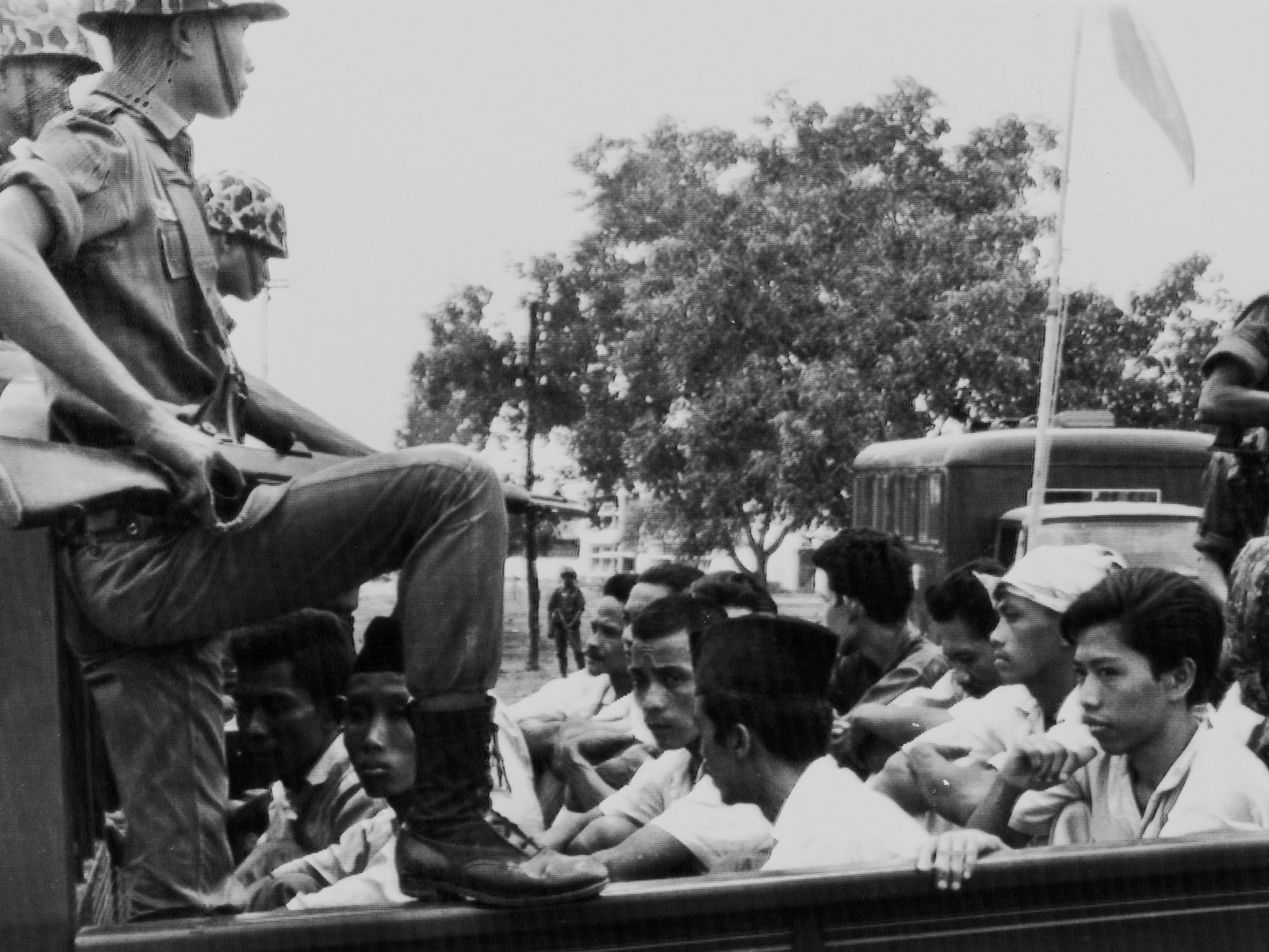 Members of the Youth Wing of the Indonesian Communist Party (Pemuda Rakjat) are watched by soldiers as they are taken to prison in Jakarta following a crackdown on communists after an abortive coup against President Sukarno's government earlier in the month