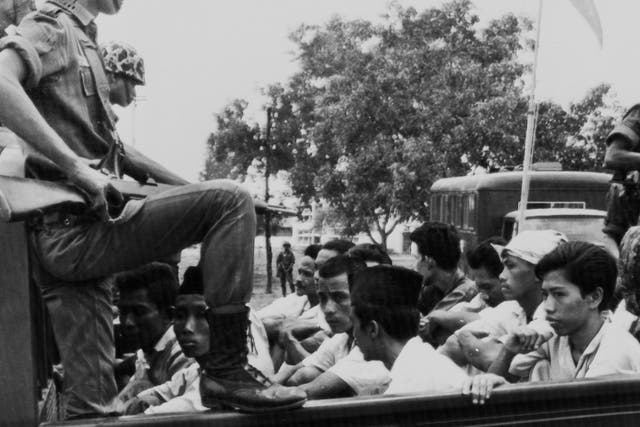 Members of the Youth Wing of the Indonesian Communist Party (Pemuda Rakjat) are watched by soldiers as they are taken to prison in Jakarta following a crackdown on communists after an abortive coup against President Sukarno's government earlier in the month