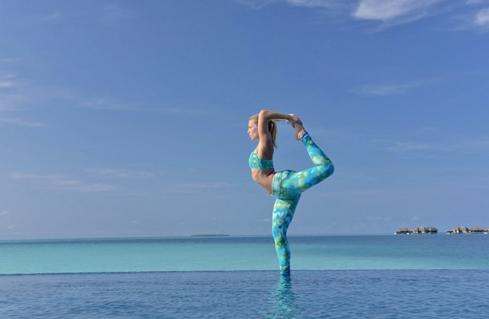 A guest at Conrad Maldives Rangali Island enjoying beach yoga