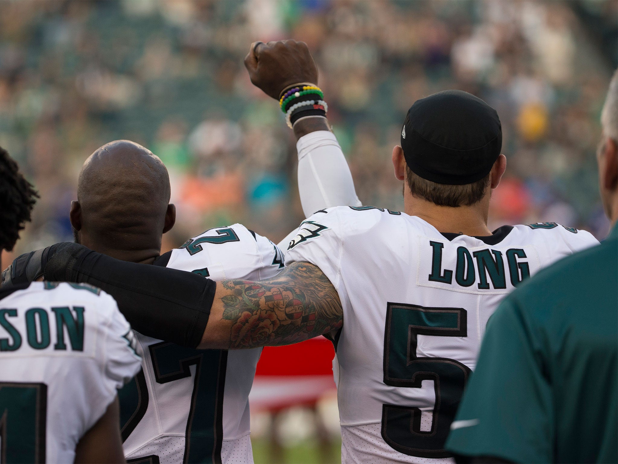 Chris Long puts an arm around teammate Malcolm Jenkins during his protest