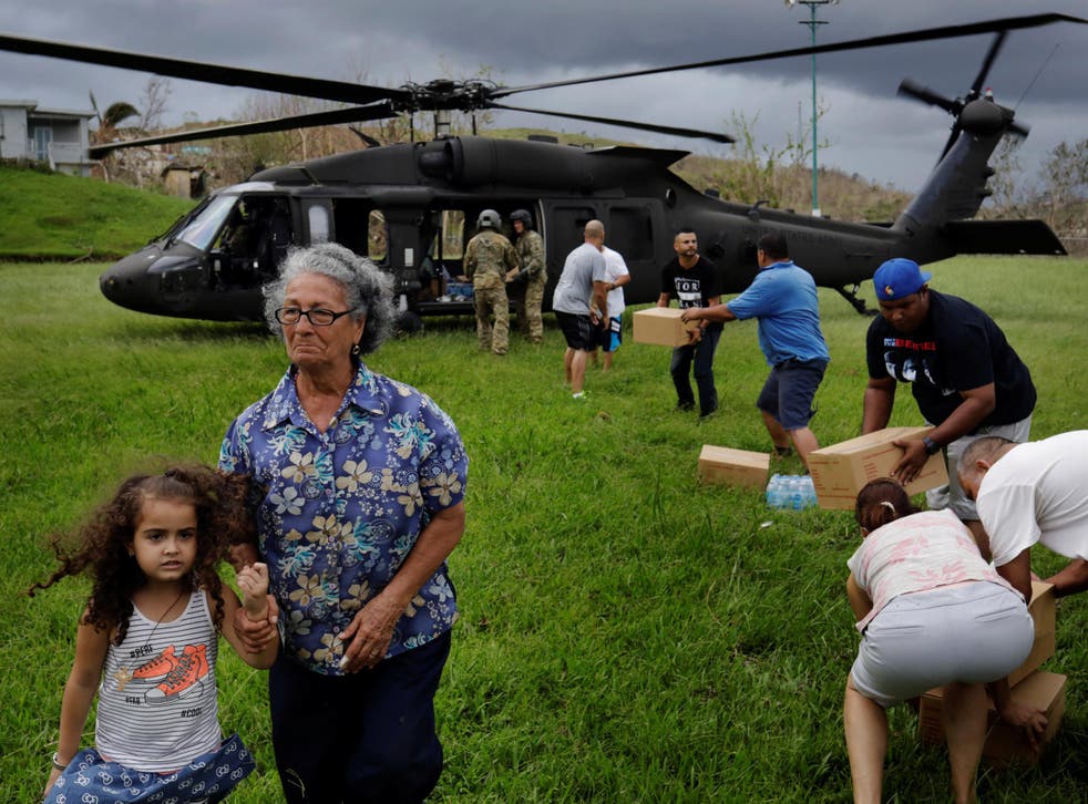 Soldiers in a UH-60 Blackhawk helicopter from the First Armored Division’s Combat Aviation Brigade deliver food and water during Hurricane Maria recovery efforts in Verde de Comerio