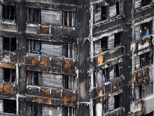 Police investigators work to gather evidence inside the burned out shell of Grenfell Tower