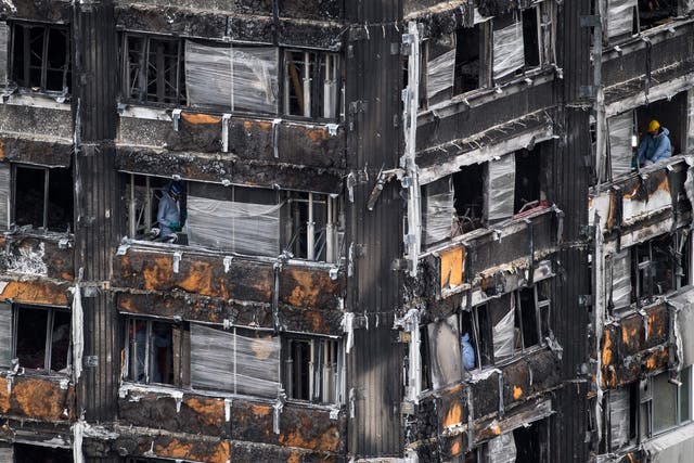 Police investigators work to gather evidence inside the burned out shell of Grenfell Tower
