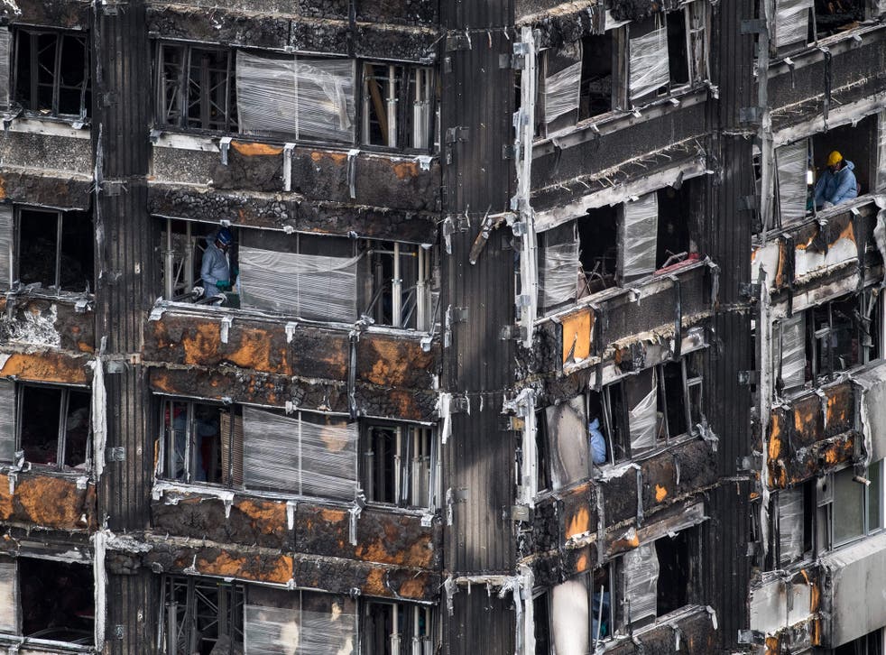 Police investigators are seen inside the burned out shell of Grenfell Tower this week