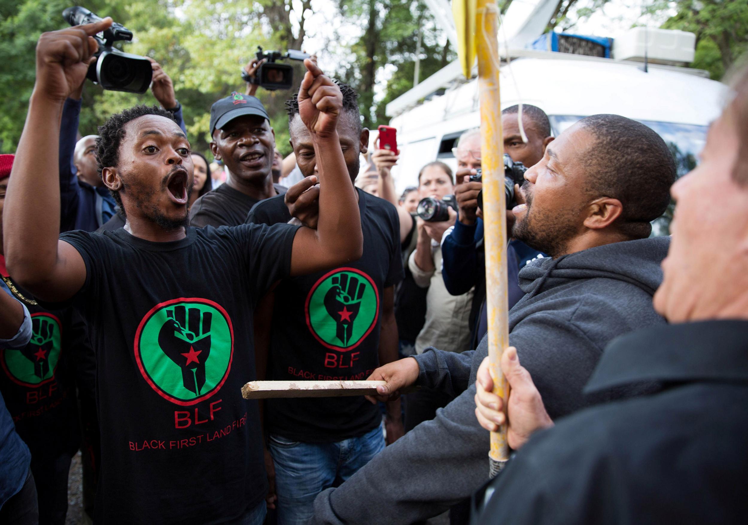 Supporters of President Jacob Zuma confront demonstrators calling for Zuma's removal outside the home of the controversial Gupta family in Johannesburg