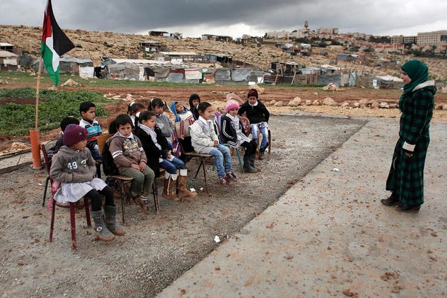 A class of Palestinian Bedouin children attend school outside after the Israeli Army forces dismantled prefabricated classrooms
