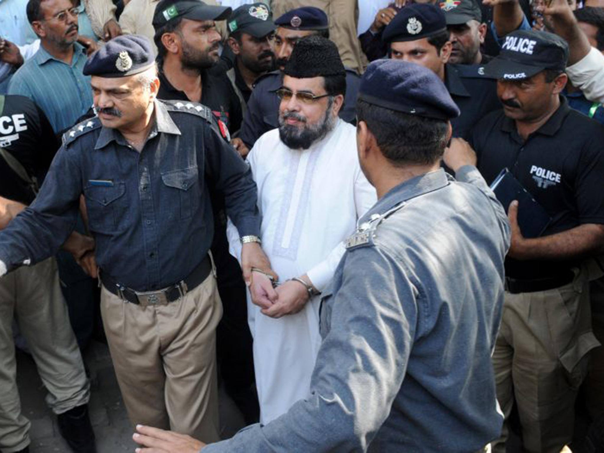 Policemen arrest Mufti Abdul Qavi, a religious cleric, who was accused of inciting the murder of Qandeel Baloch