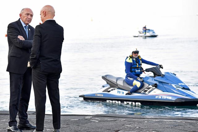 Police look on as Italy’s interior minister Marco Minniti welcomes France’s interior minister Gerard Collomb (L) to the summit