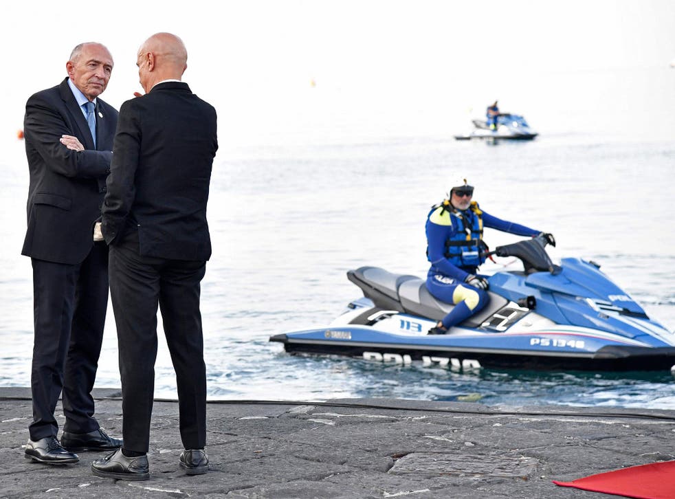 Police look on as Italy’s interior minister Marco Minniti welcomes France’s interior minister Gerard Collomb (L) to the summit
