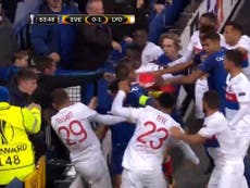 Everton fan appears to throw punch at Lyon player while holding child