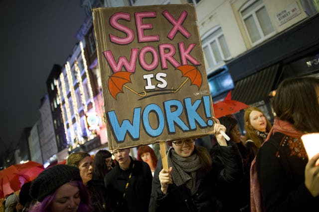 A protester holds a placard while marching through London after a candle-lit vigil to mark the international day to end violence against sex workers