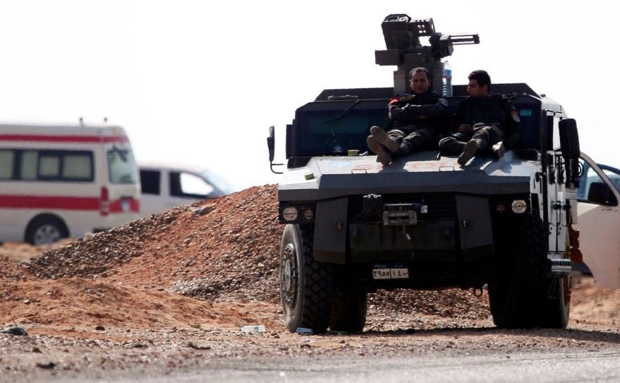 Egyptian security forces rest on top of an armoured vehicle near the site of the attack